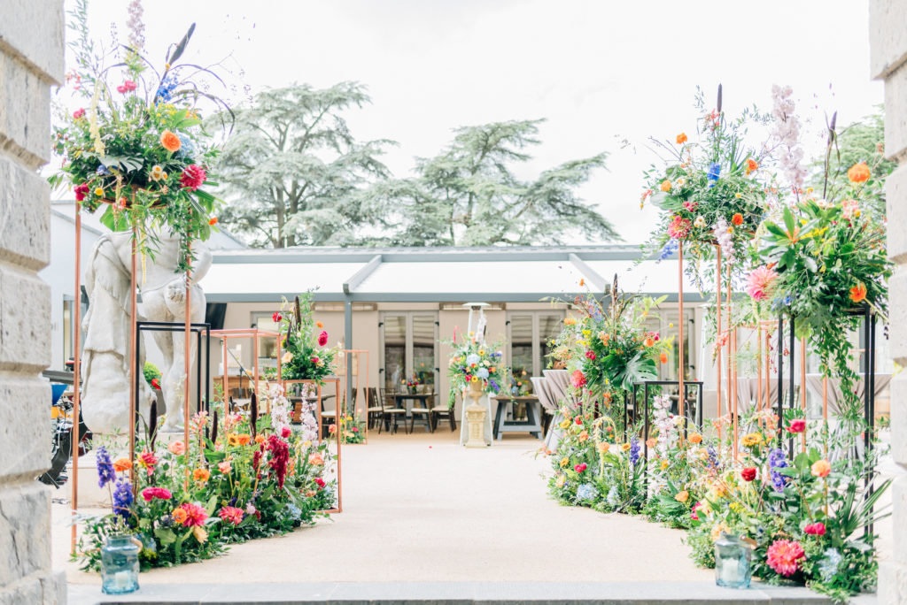 bright floral arrangements with geostands lining the entrance