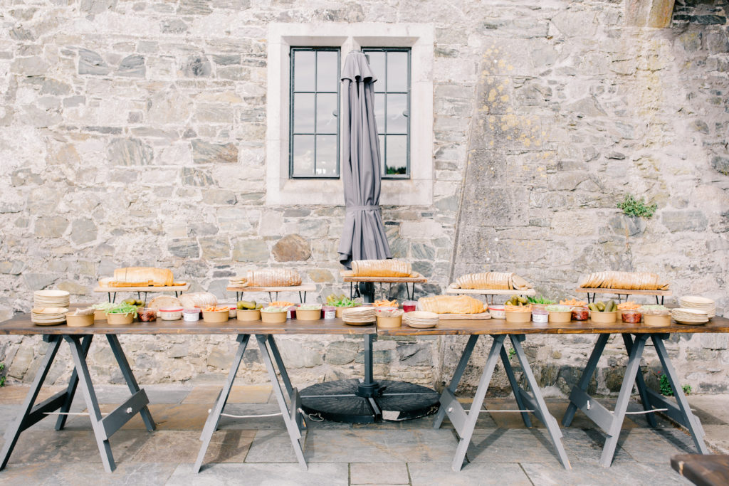 stone wall with a wooden table full of snacks
